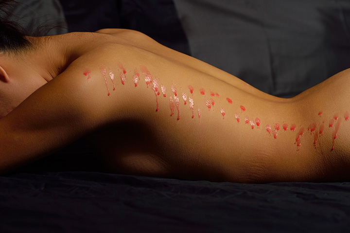 Close up shot of woman's body during wax play.